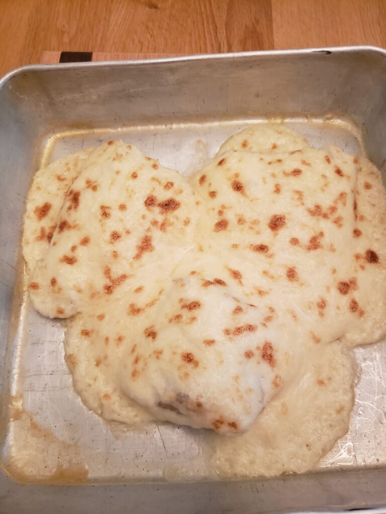 crab topped fish in baking pan ready to eat