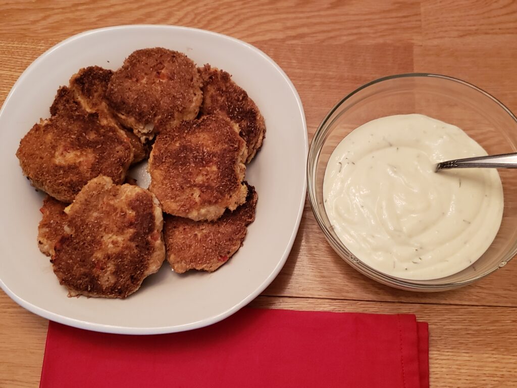 gluten free salmon cakes on a white plate next to lemon herb mayonnaise in a bowl