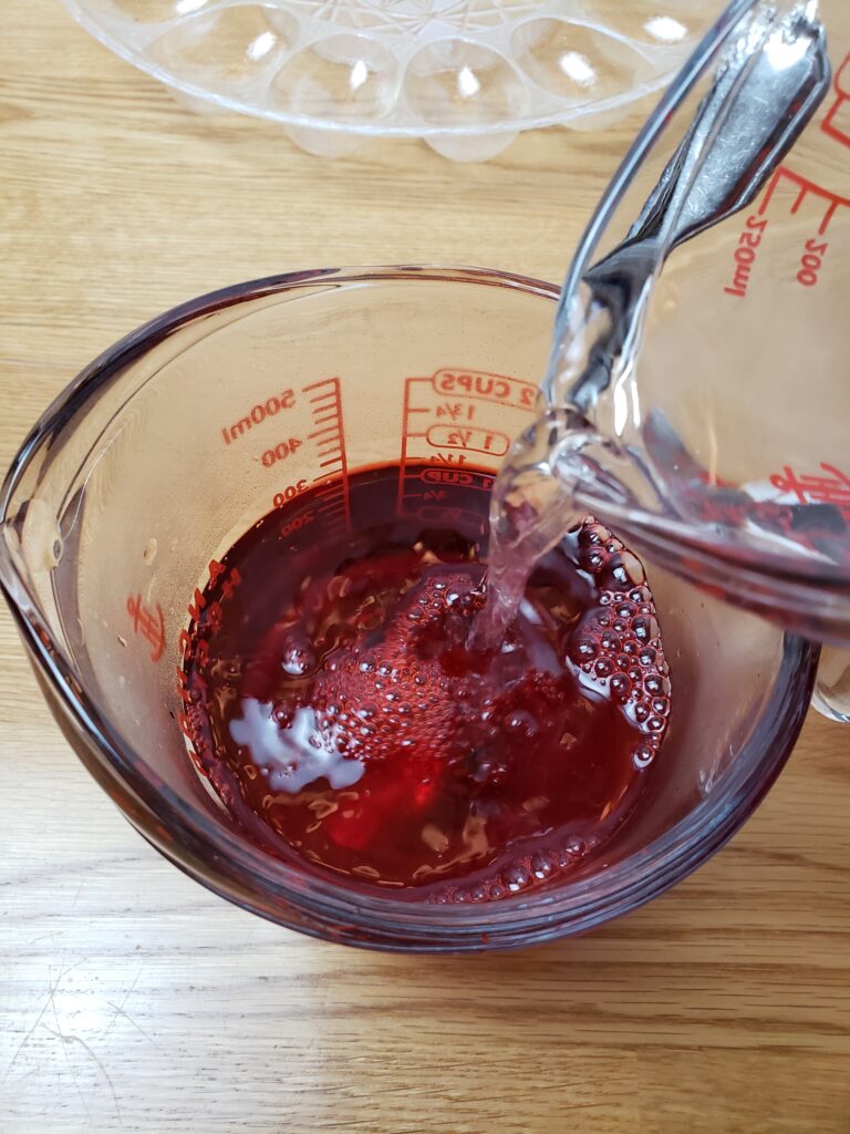 pouring water into red Jell-o