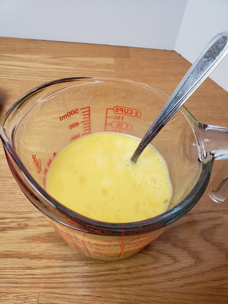 scrambled eggs in a measuring glass