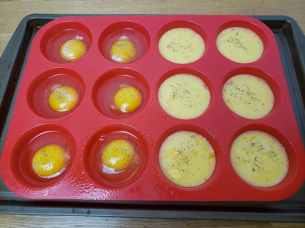 muffin pan full of oven baked eggs before baking