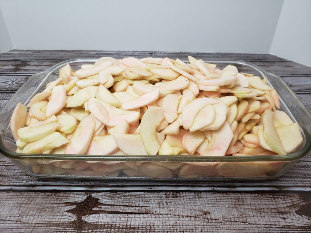sliced apples piled high in baking pan