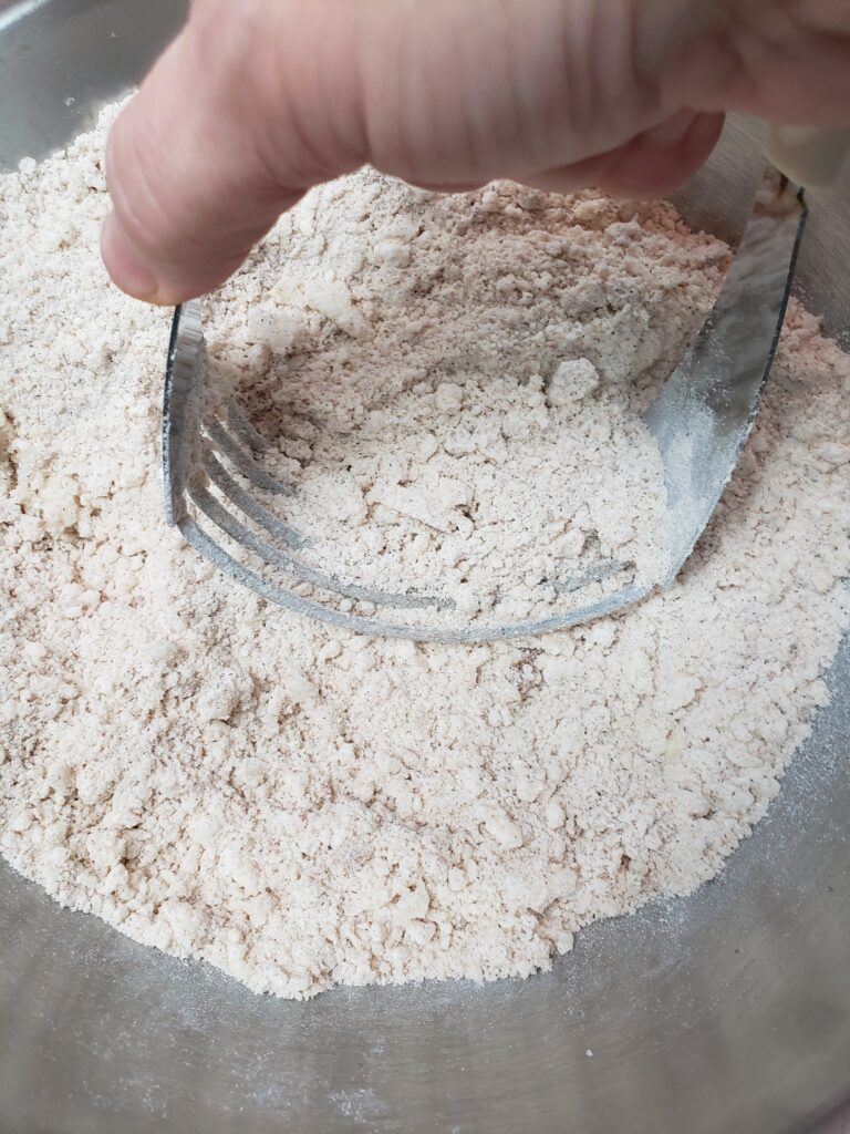 using pastry cutter to mix sugar, flour, cinnamon and butter
