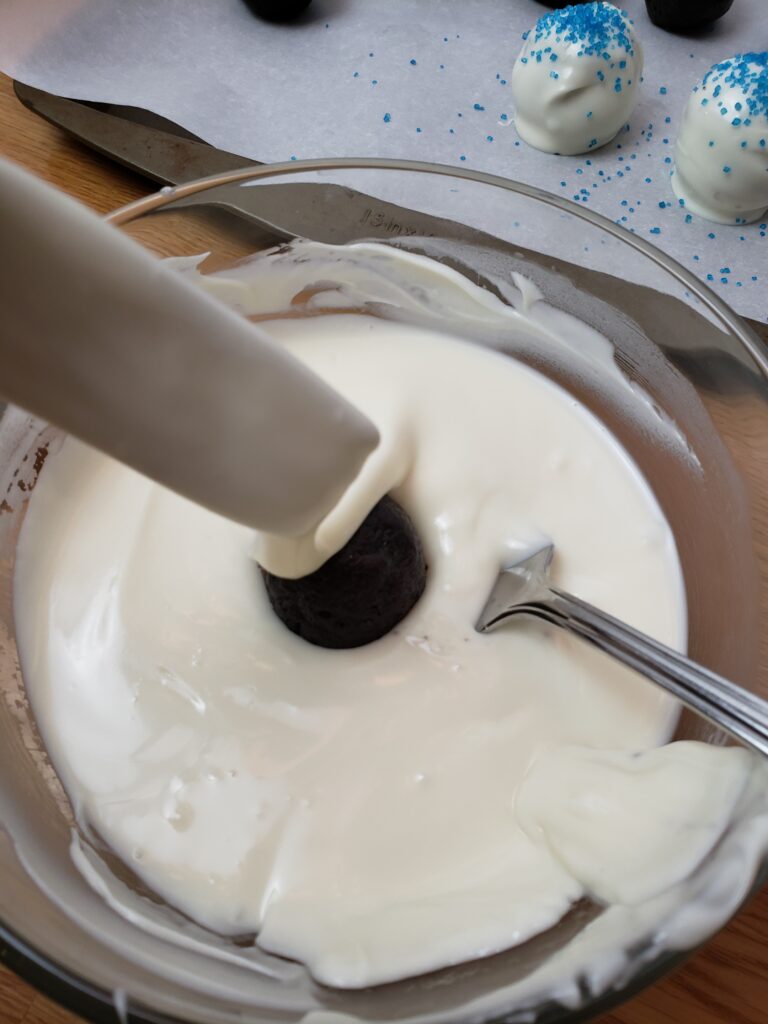 dripping truffle into melted white chocolate