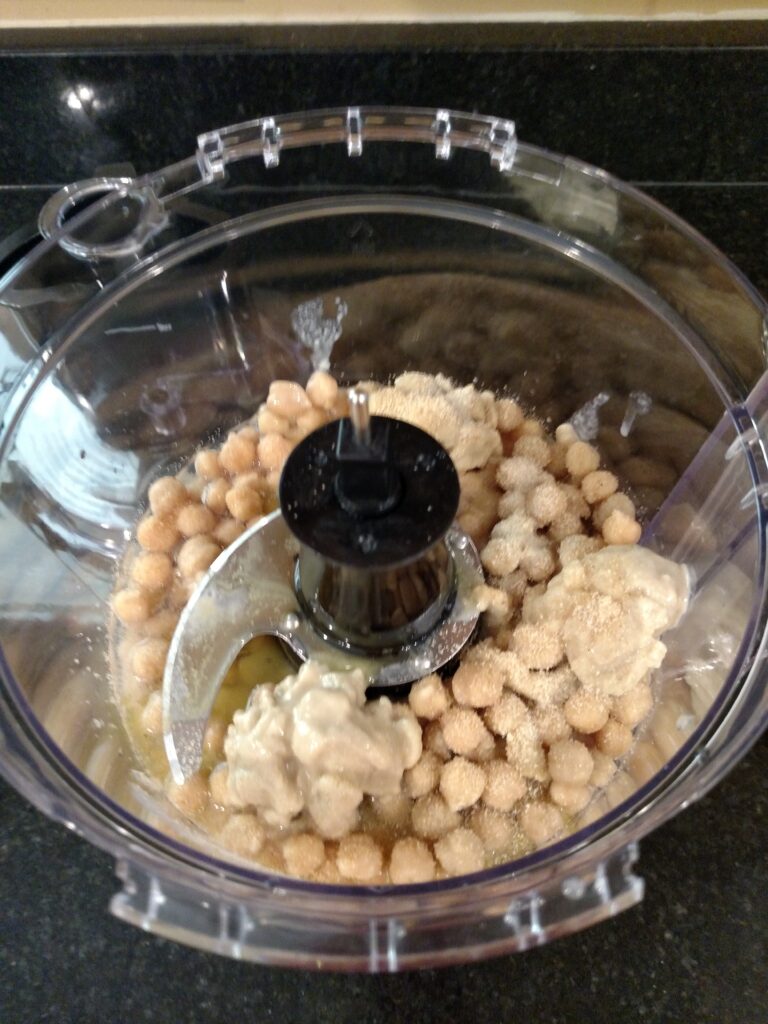 basic homemade hummus ingredients in food processor before being processed