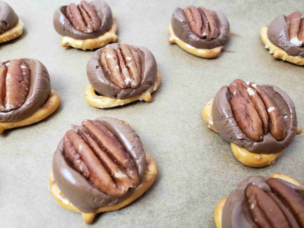 caramel pretzel turtles cooling on baking sheet