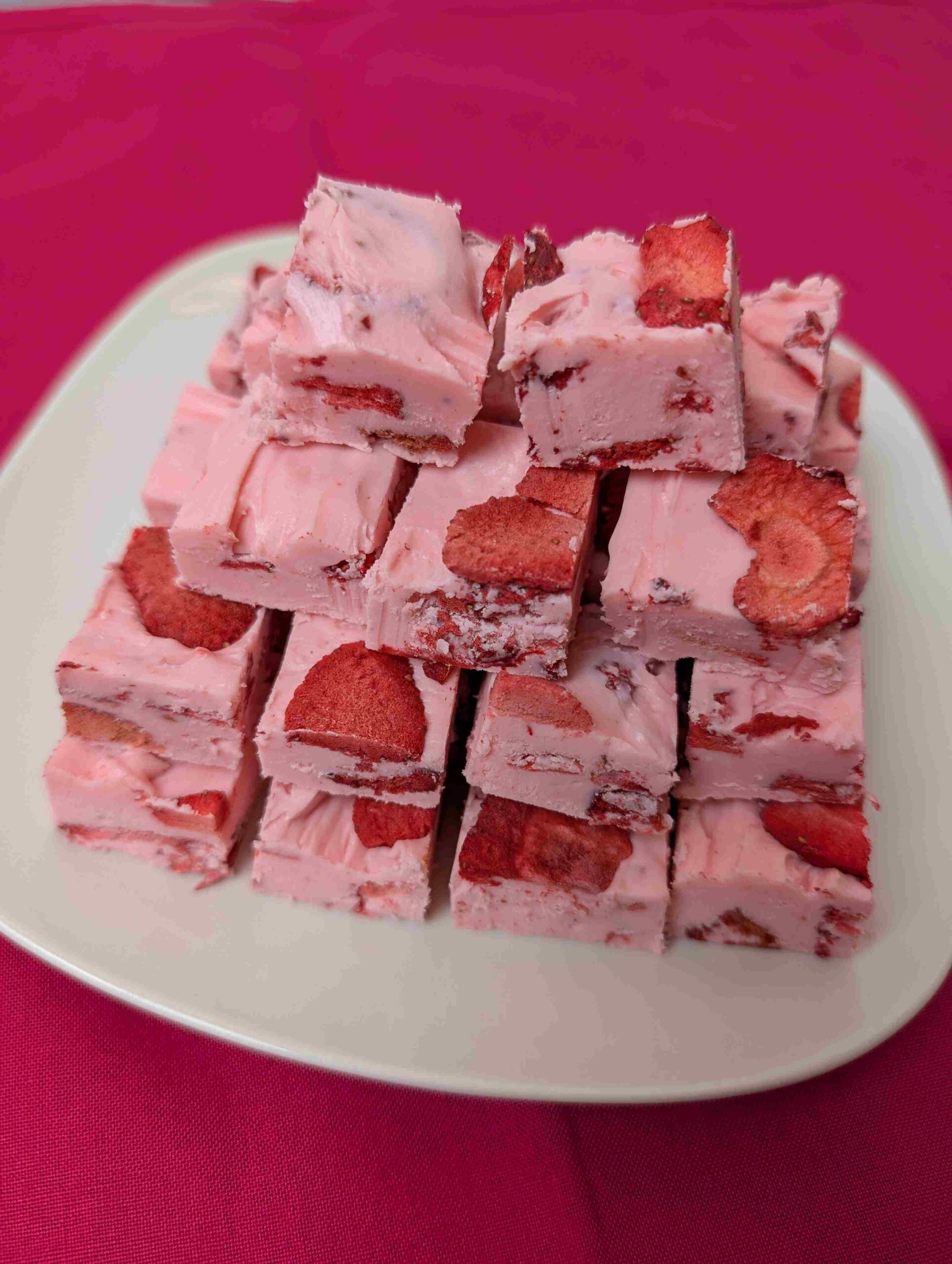 easy strawberry fudge on a white plate and dark pink napkin