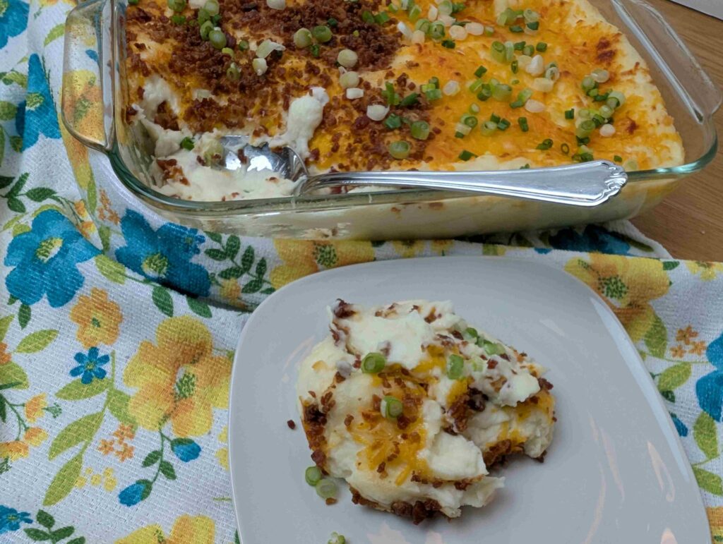 make ahead mashed potato casserole shown with a spoonful on a white dish